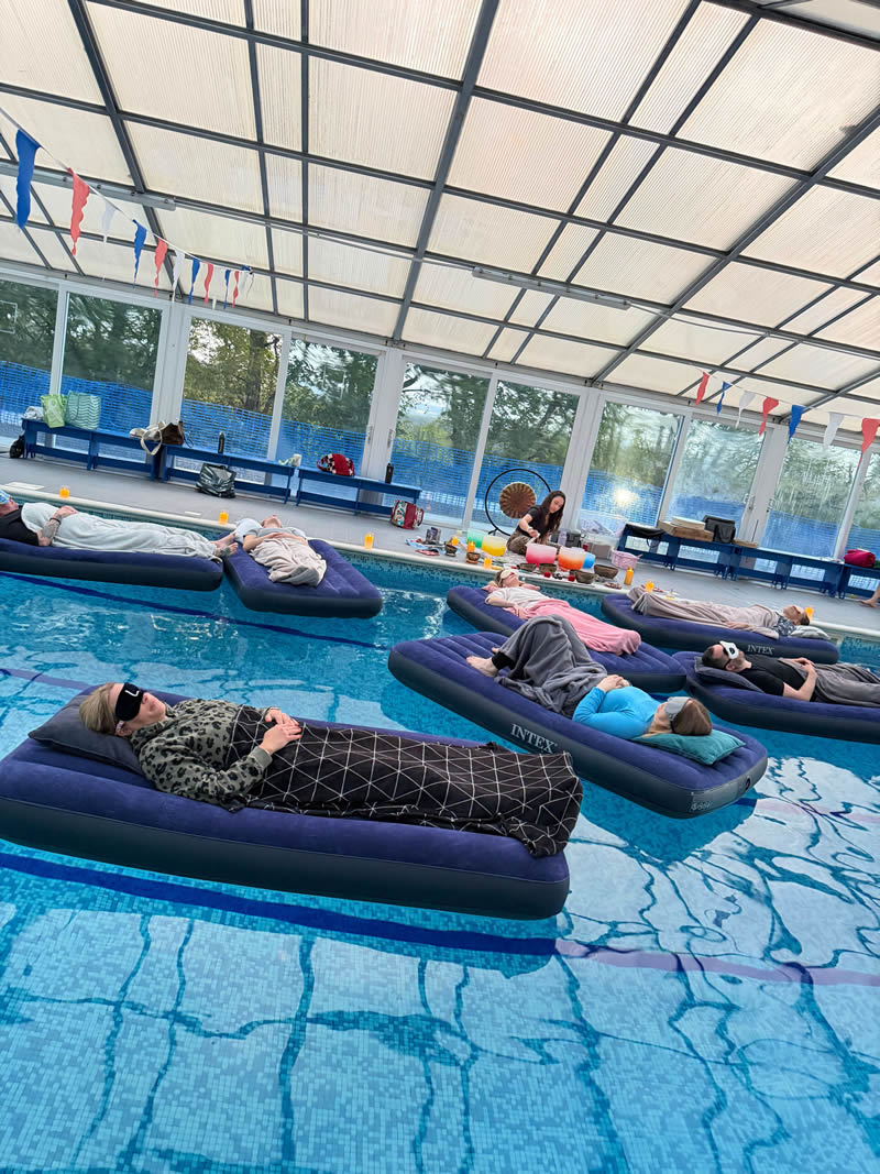 sound bath participants relaxing on floating beds